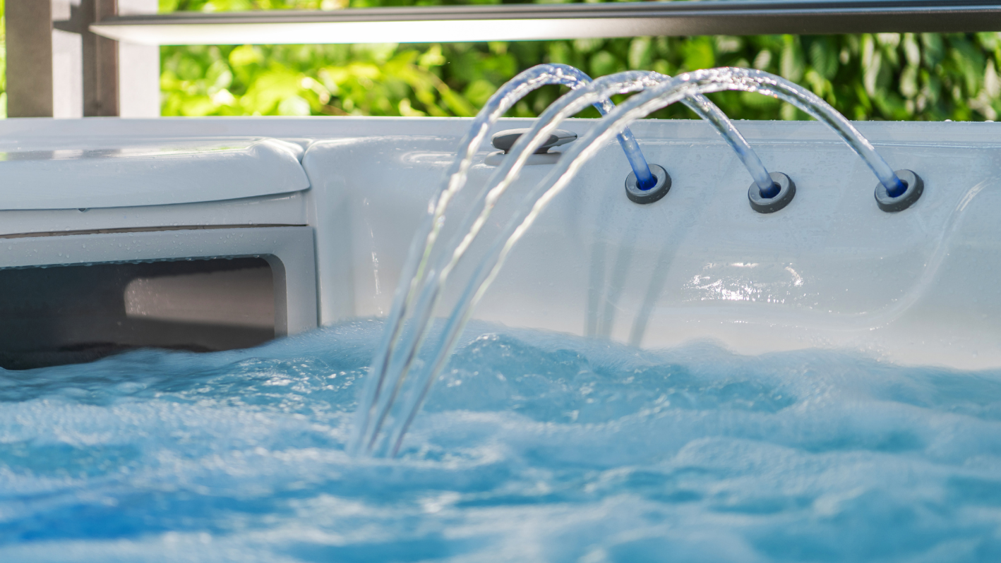 A hot tub filled with blue water and water spouting out of it